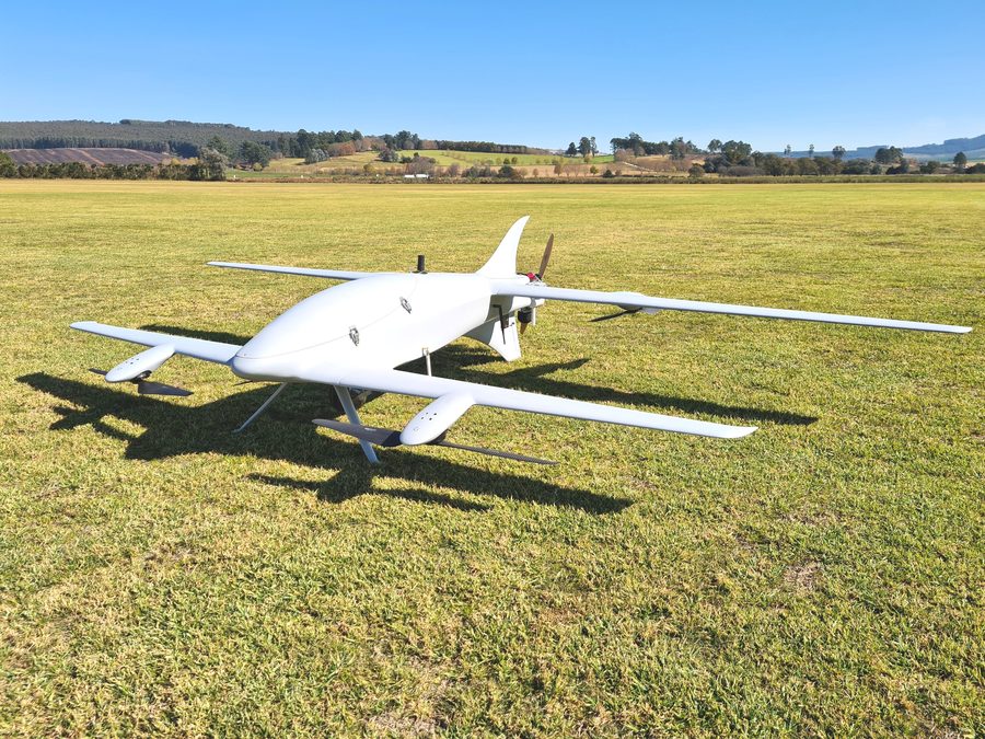 Fixed-wing VTOL survey aircraft on a grass strip