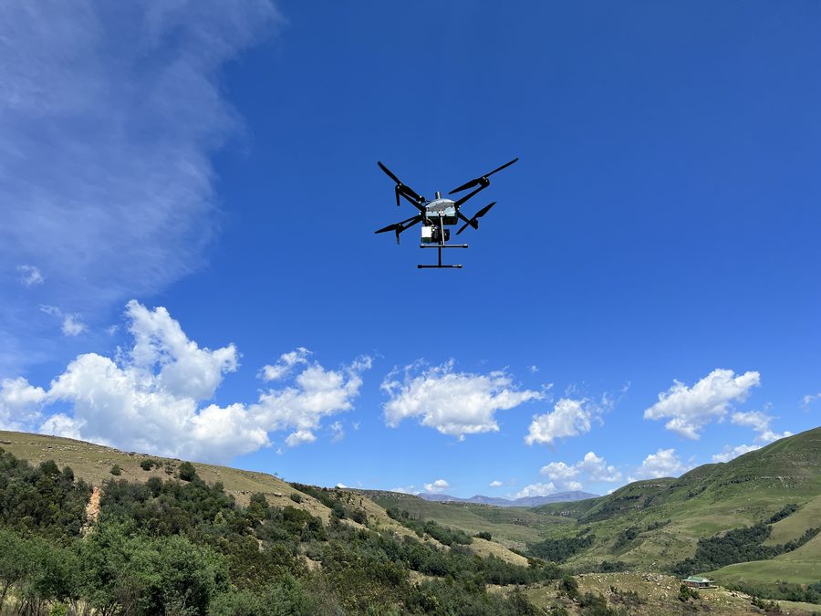 Multirotor aircraft hovering over hills