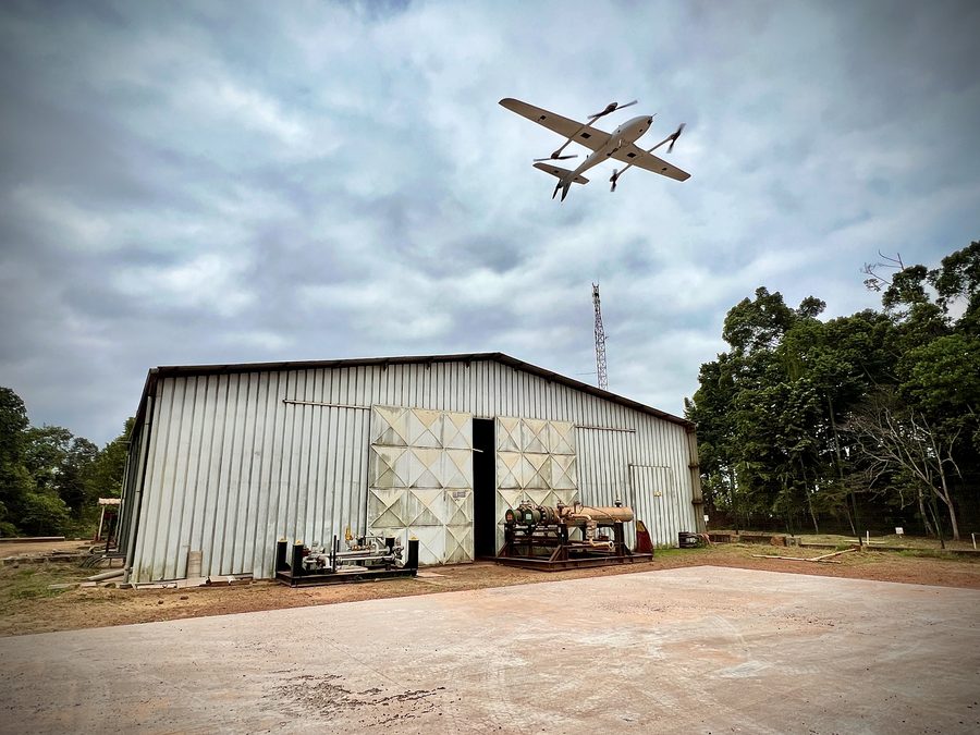 VTOL aircraft launching in front of a hangar