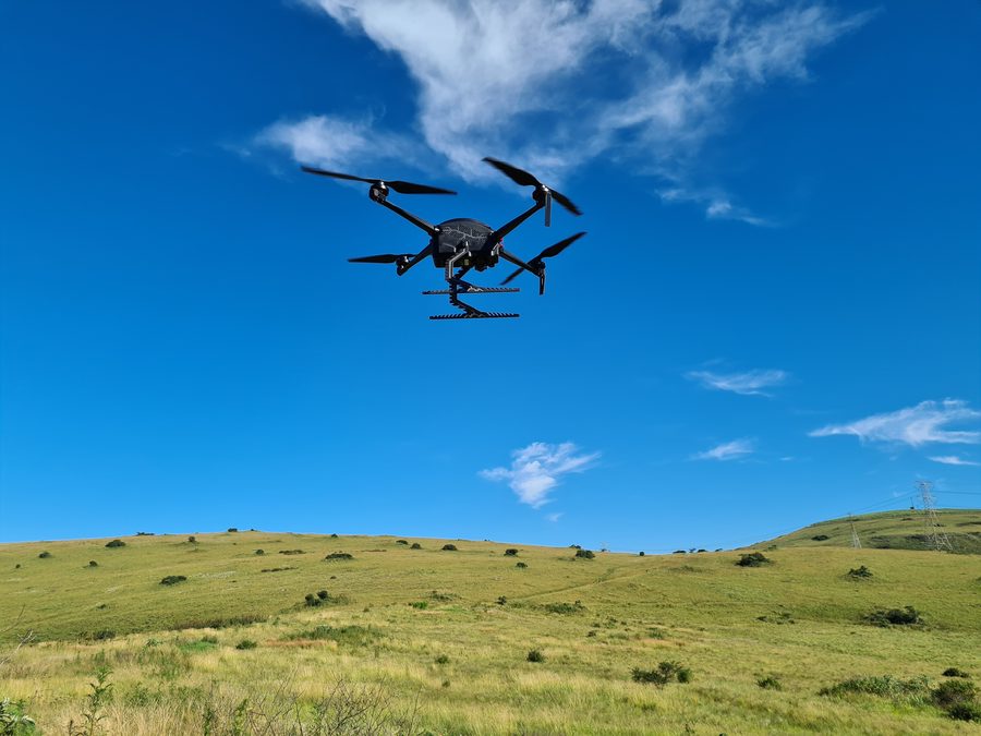 Multirotor aircraft in flight over grassland